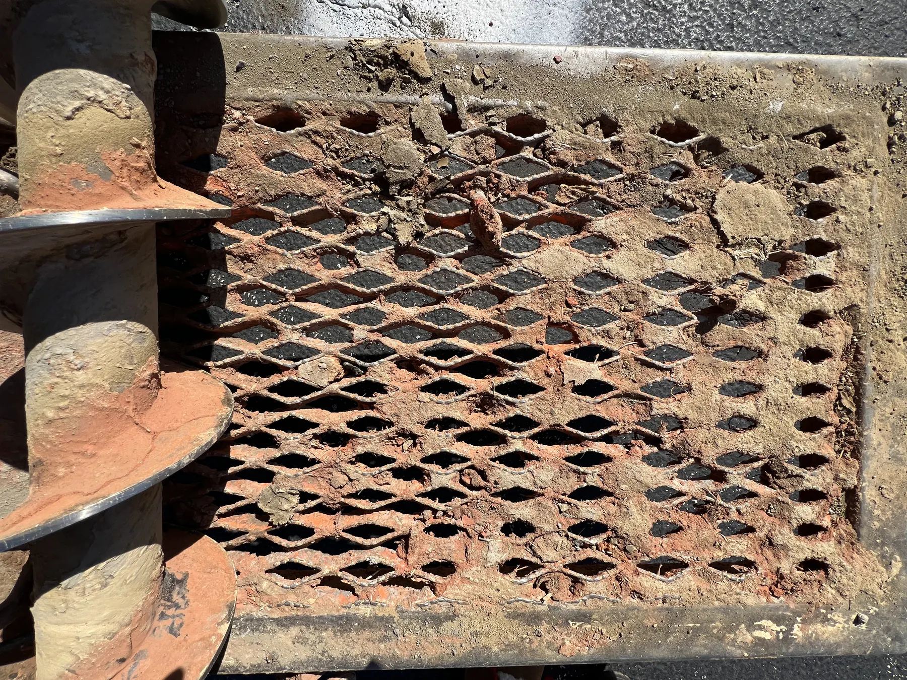 Rust-toned expanded-metal grating on drilling equipment in a repeating diamond pattern