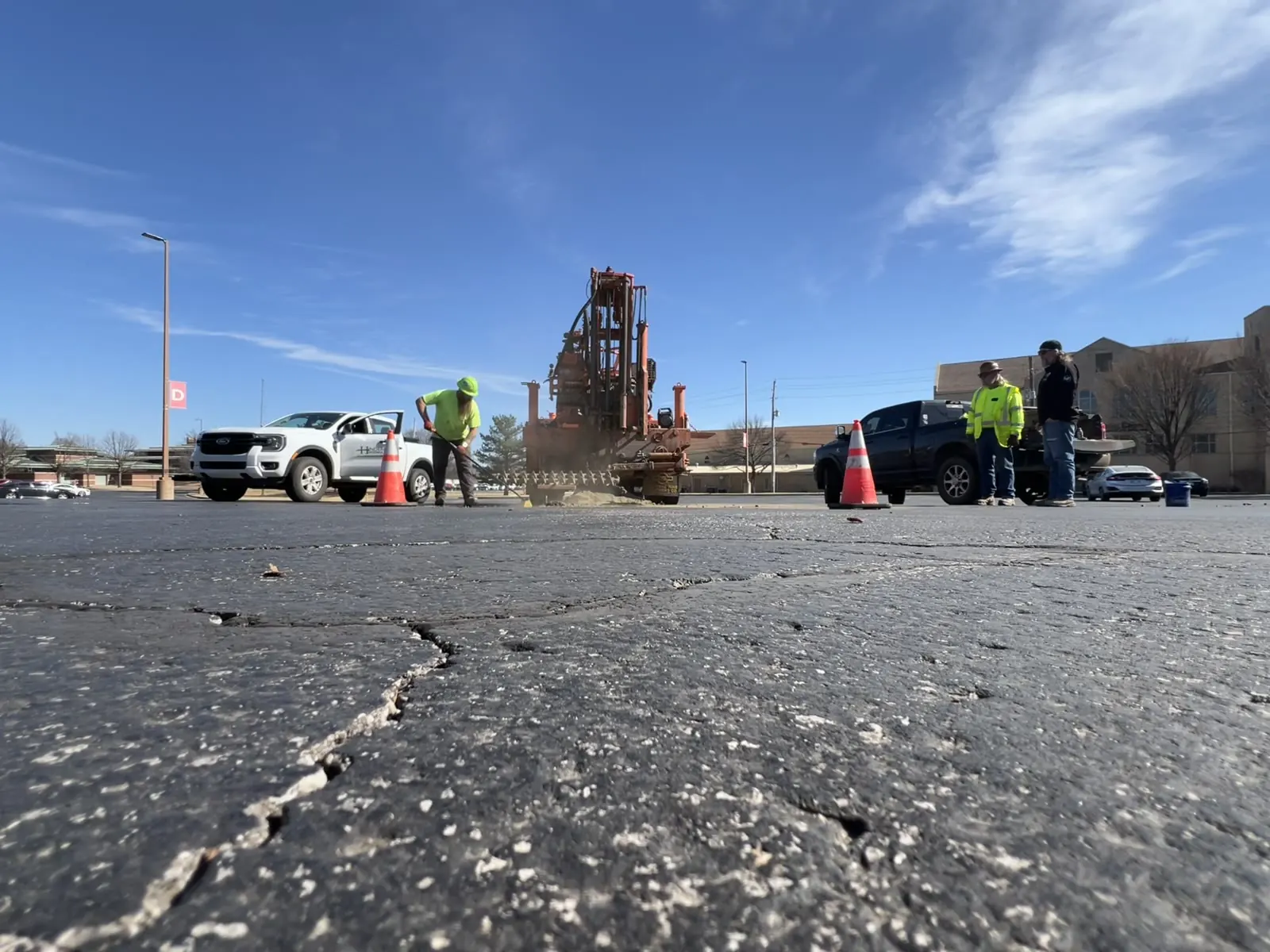 Hunter field crew operating a drilling rig on a paved project site